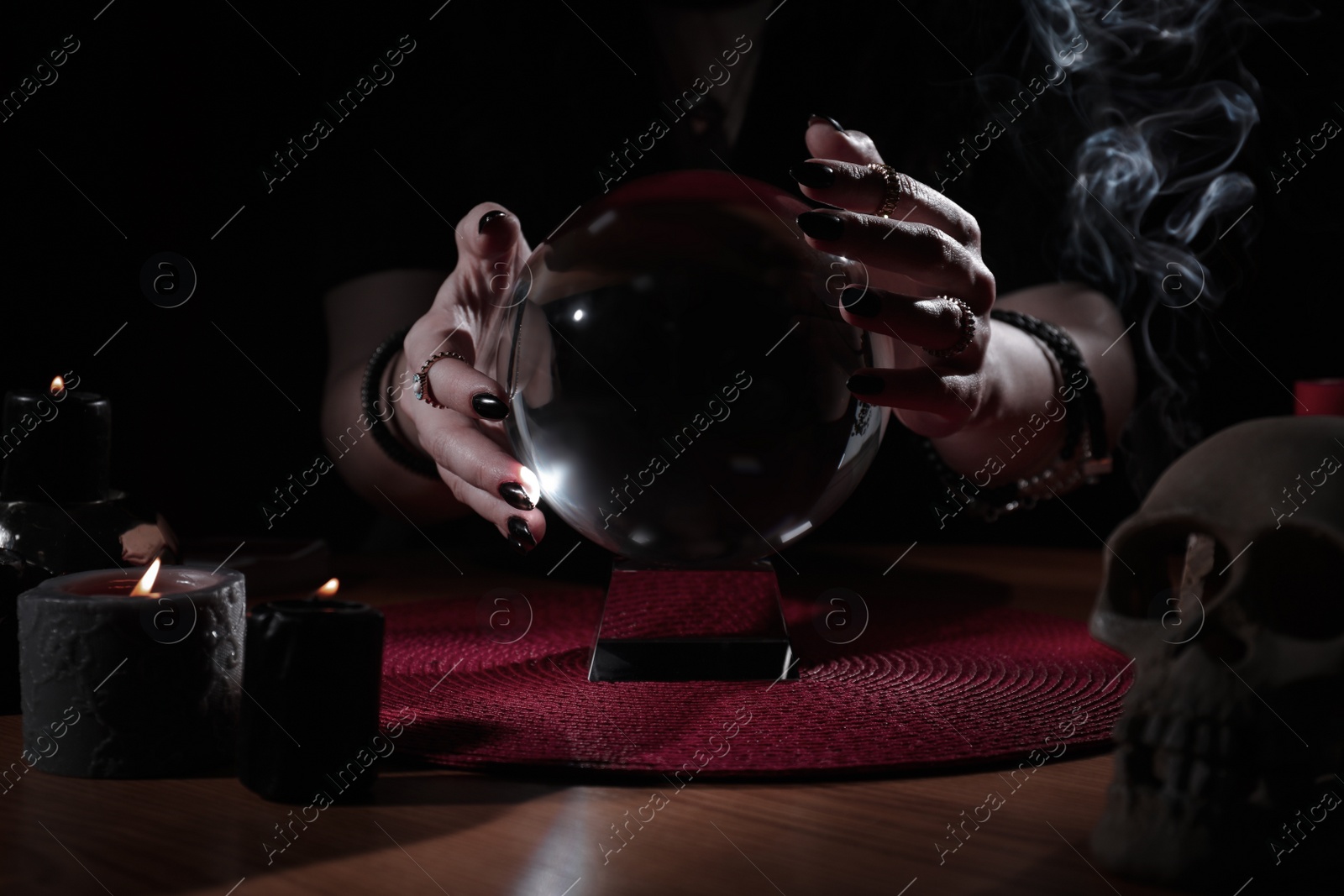 Photo of Soothsayer using crystal ball to predict future at table indoors, closeup