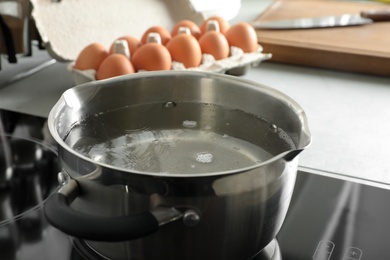 Photo of Pot with boiling water on electric stove in kitchen