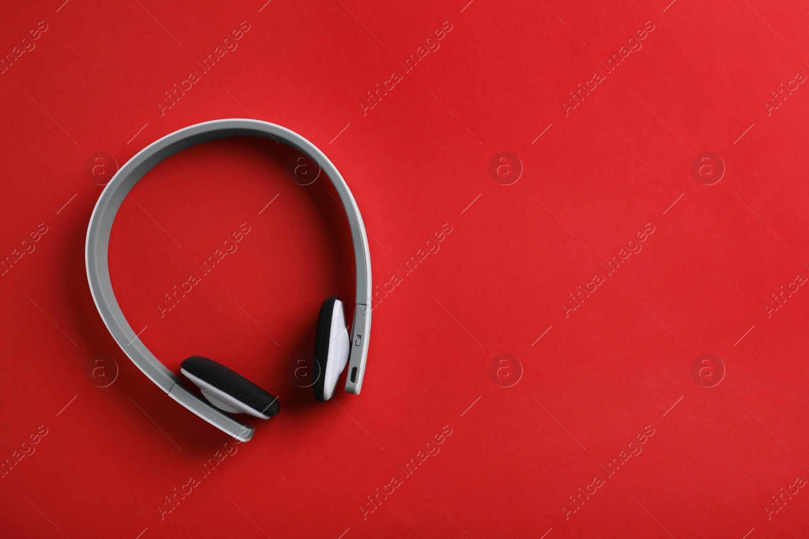 Photo of Wireless headphones on color background, top view. Space for text