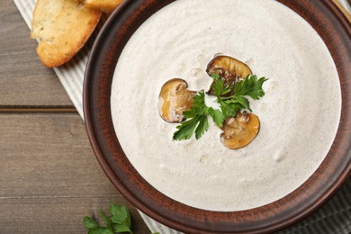 Photo of Fresh homemade mushroom soup in ceramic bowl on wooden table