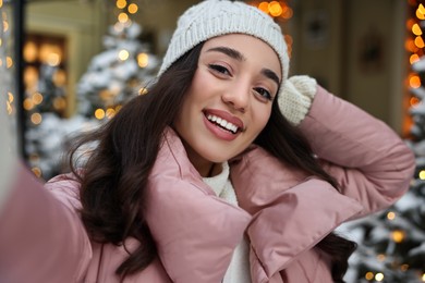 Portrait of smiling woman taking selfie on city street in winter