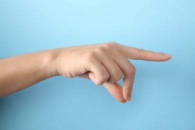 Photo of Woman showing hand sign on color background, closeup. Body language