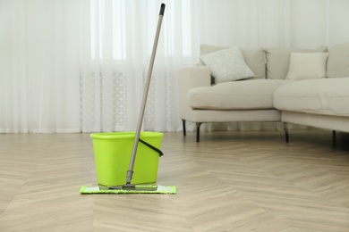 Bucket and mop on floor at home. Cleaning equipment