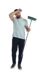 Tired young man with broom on white background