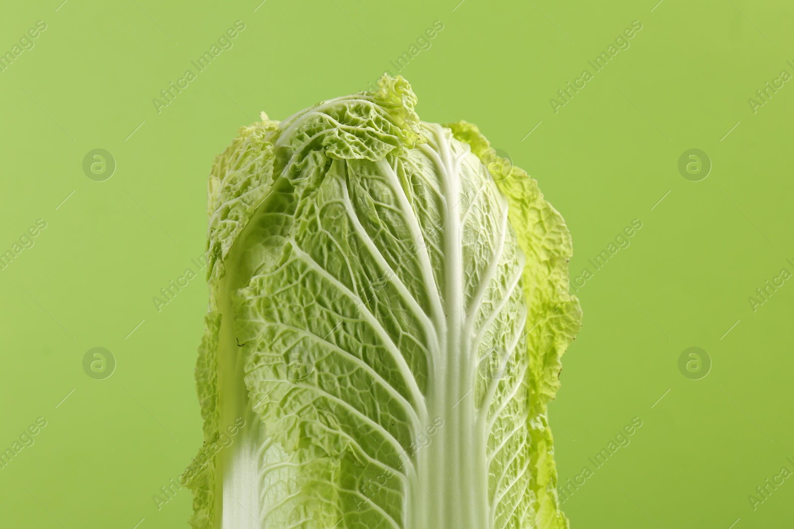 Photo of Fresh ripe Chinese cabbage on light green background, closeup