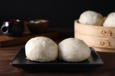 Delicious Chinese steamed buns on wooden table, closeup