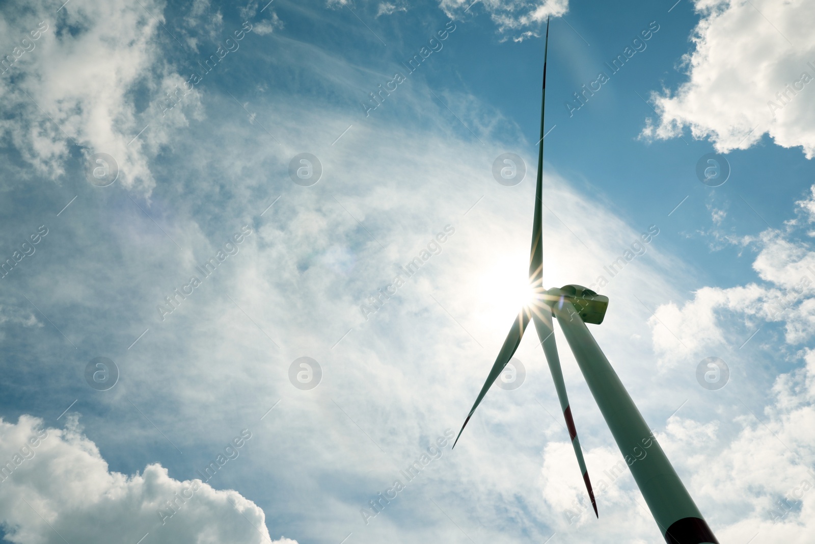 Photo of Modern wind turbine against cloudy sky, low angle view. Alternative energy source