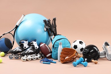 Many different sports equipment on beige background