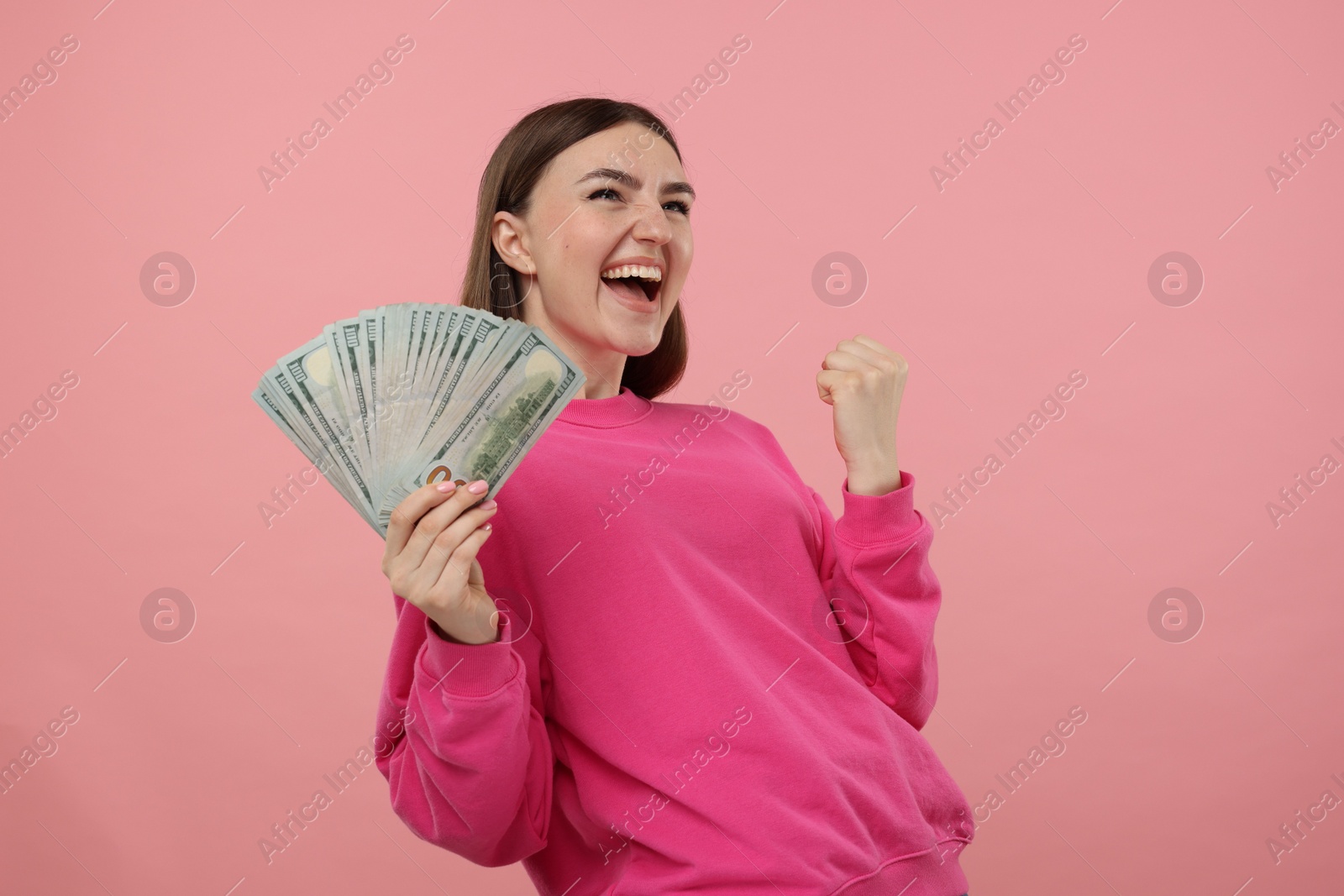 Photo of Happy woman with dollar banknotes on pink background