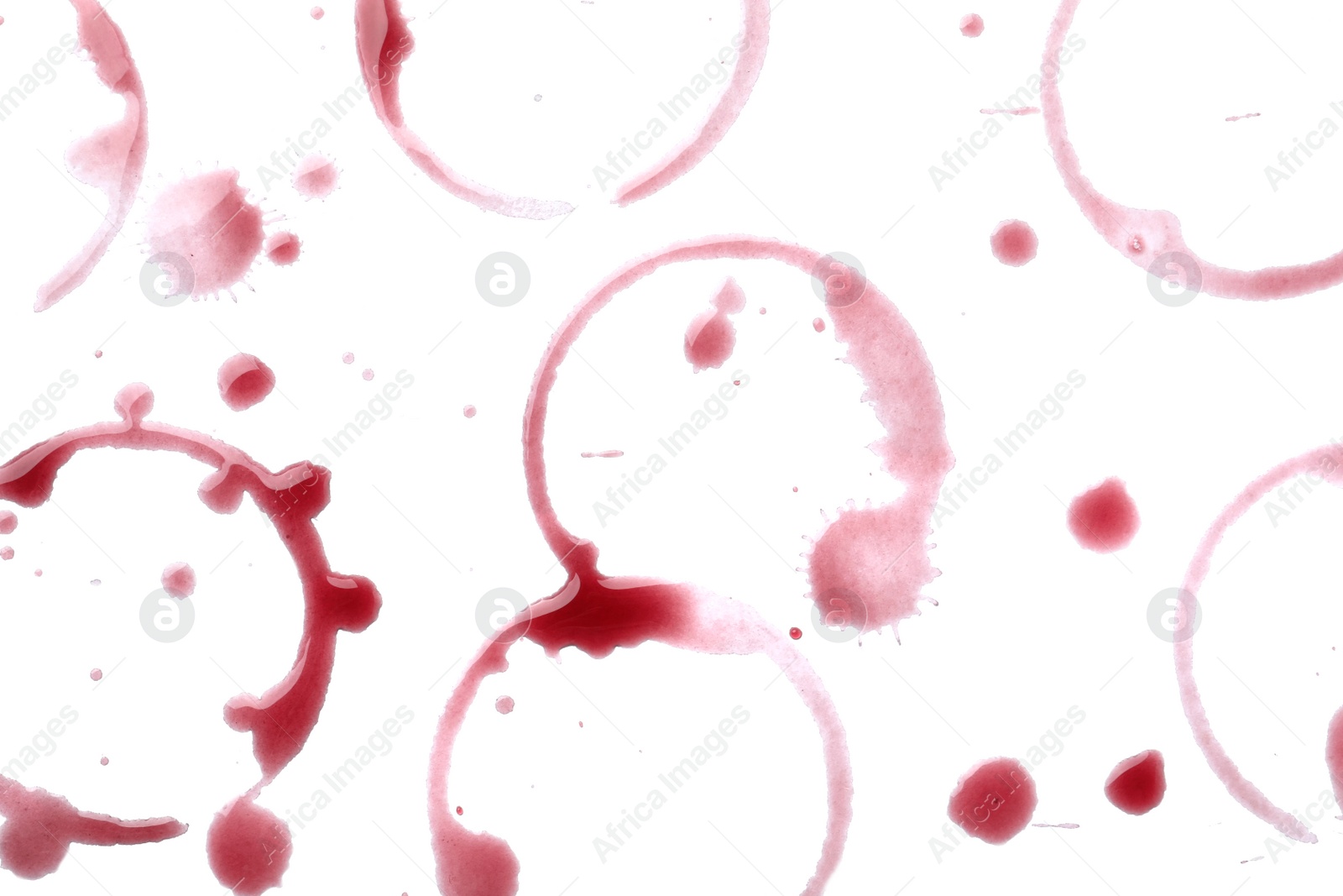 Photo of Red wine rings and drops on white background, top view