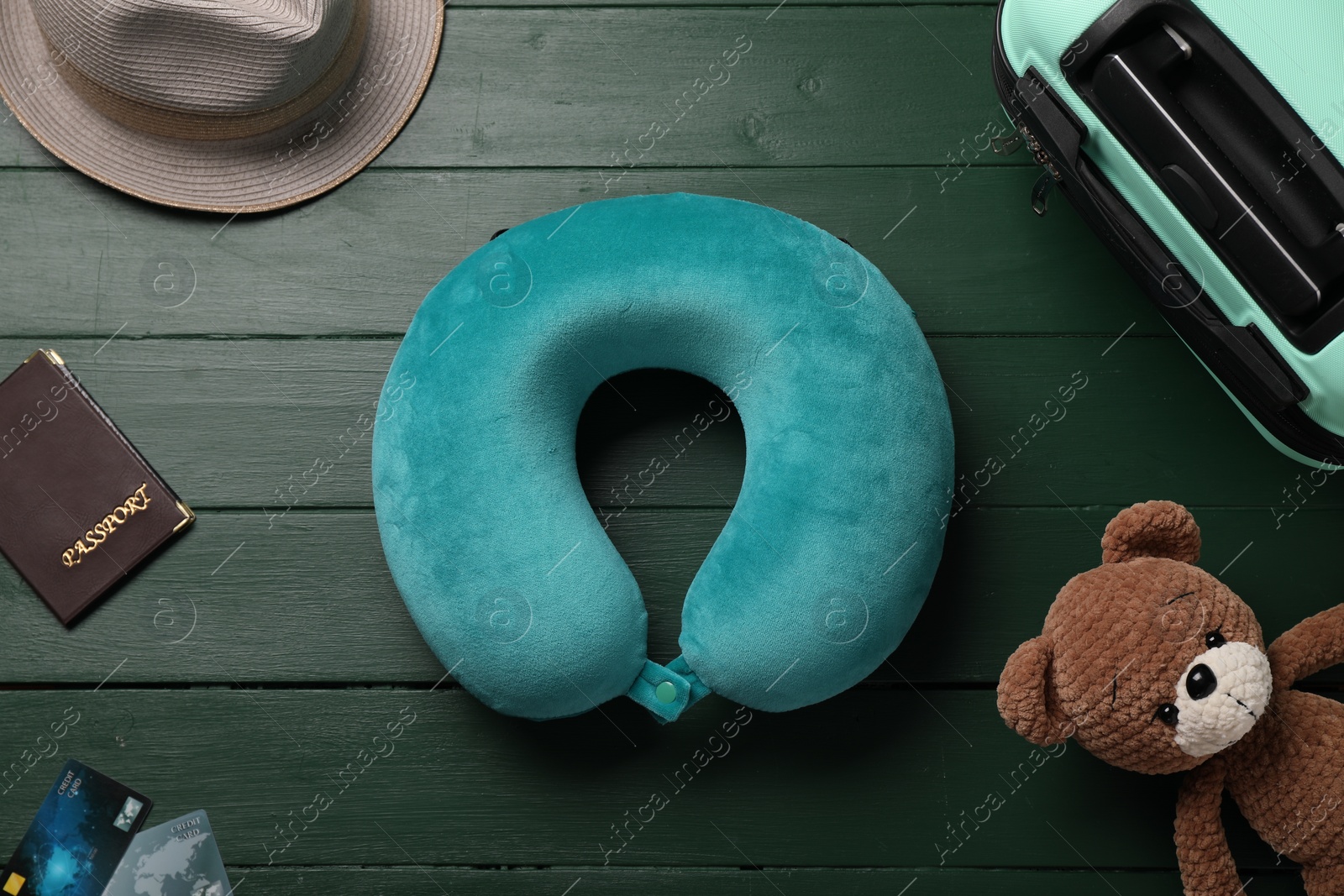 Photo of Flat lay composition with turquoise travel pillow on green wooden background