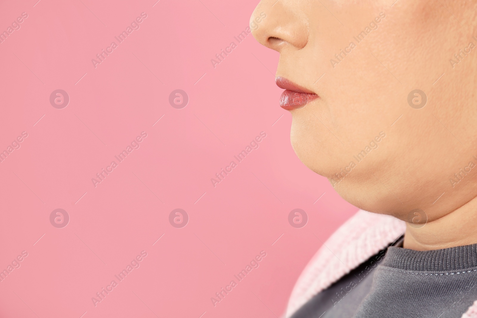 Photo of Woman with double chin on pink background, closeup. Space for text