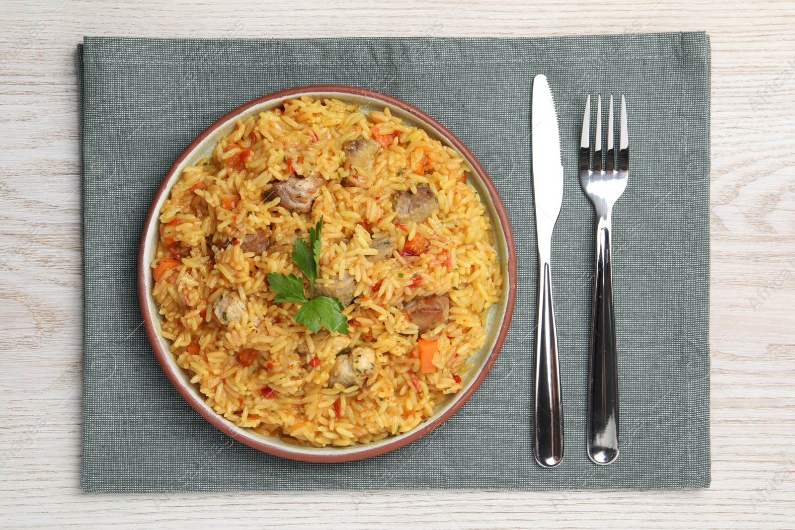 Photo of Delicious pilaf with meat served on white wooden table, top view