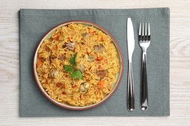 Photo of Delicious pilaf with meat served on white wooden table, top view