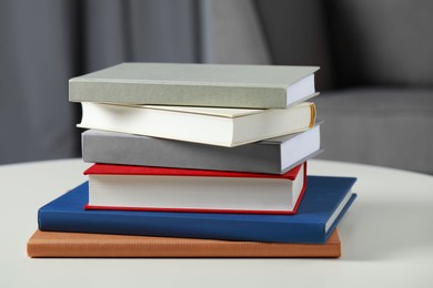 Stack of hardcover books on white table, closeup