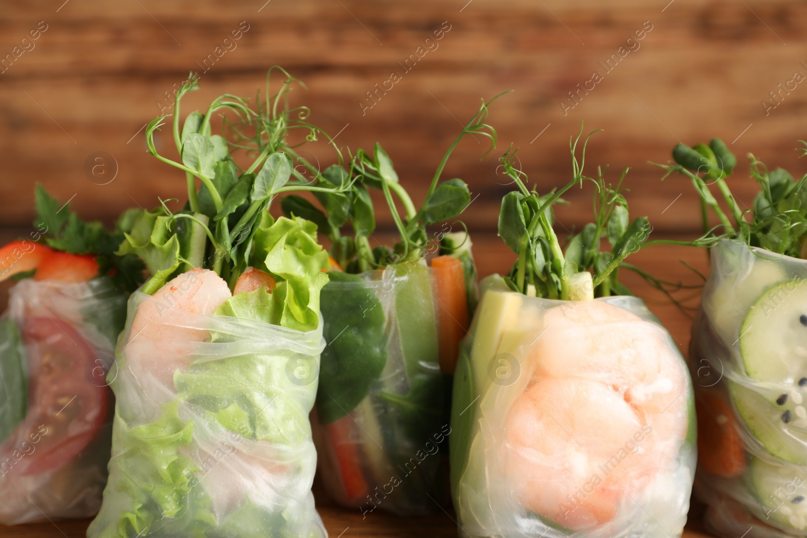Photo of Many different delicious rolls wrapped in rice paper, closeup