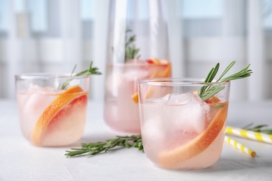 Refreshing grapefruit cocktail with rosemary on table