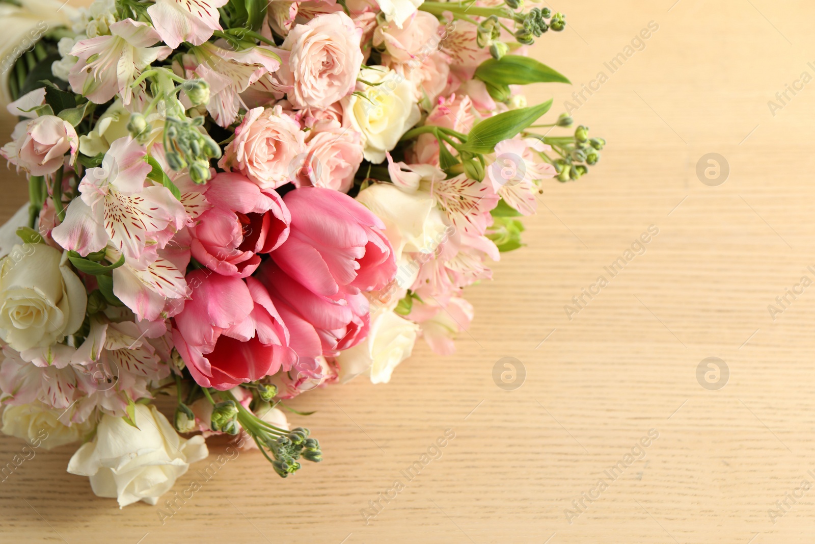 Photo of Beautiful bouquet of fresh flowers on wooden table, closeup. Space for text