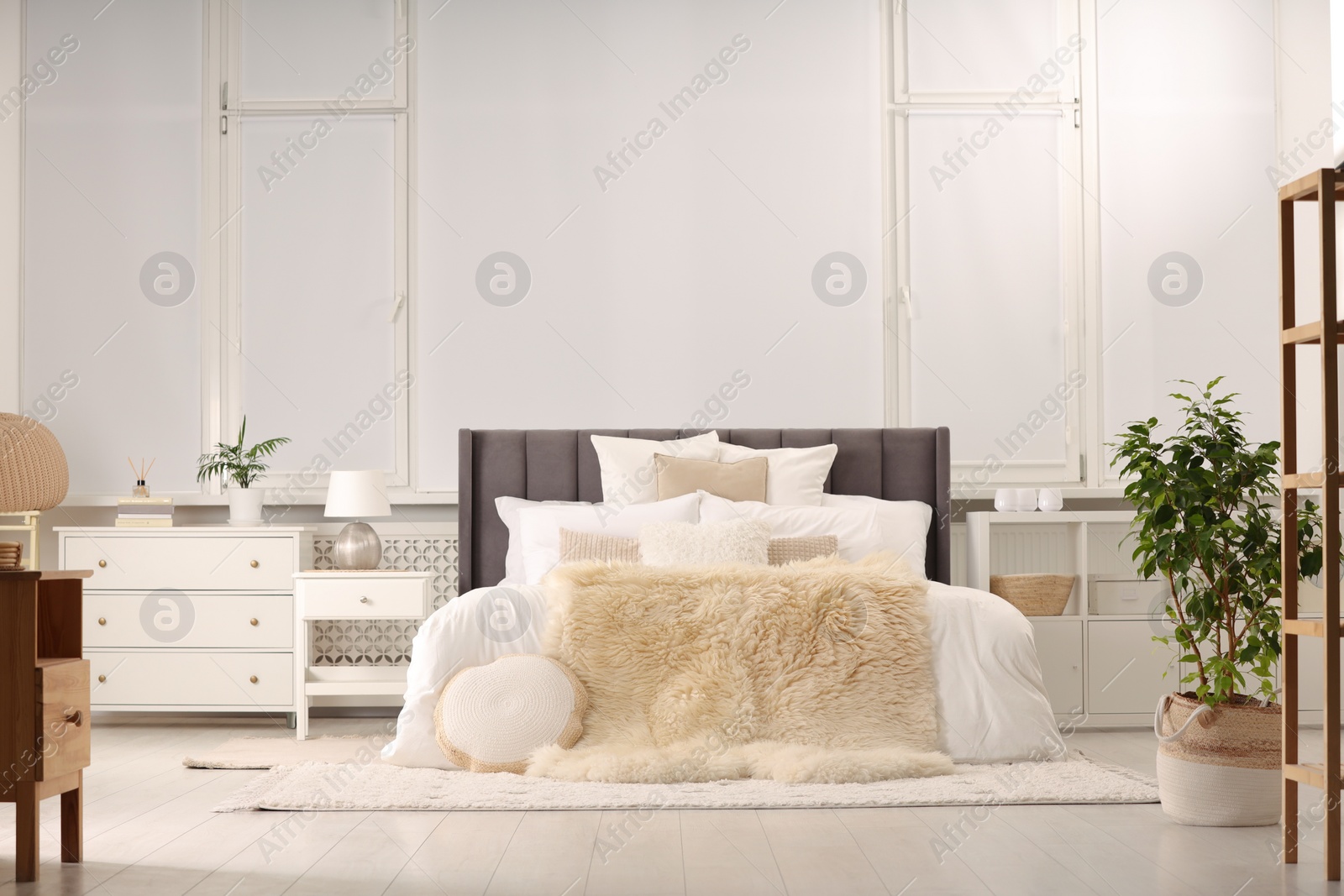 Photo of Stylish soft light bedroom interior with large comfortable bed