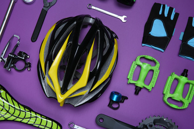 Set of different bicycle tools, accessories and parts on purple background, flat lay