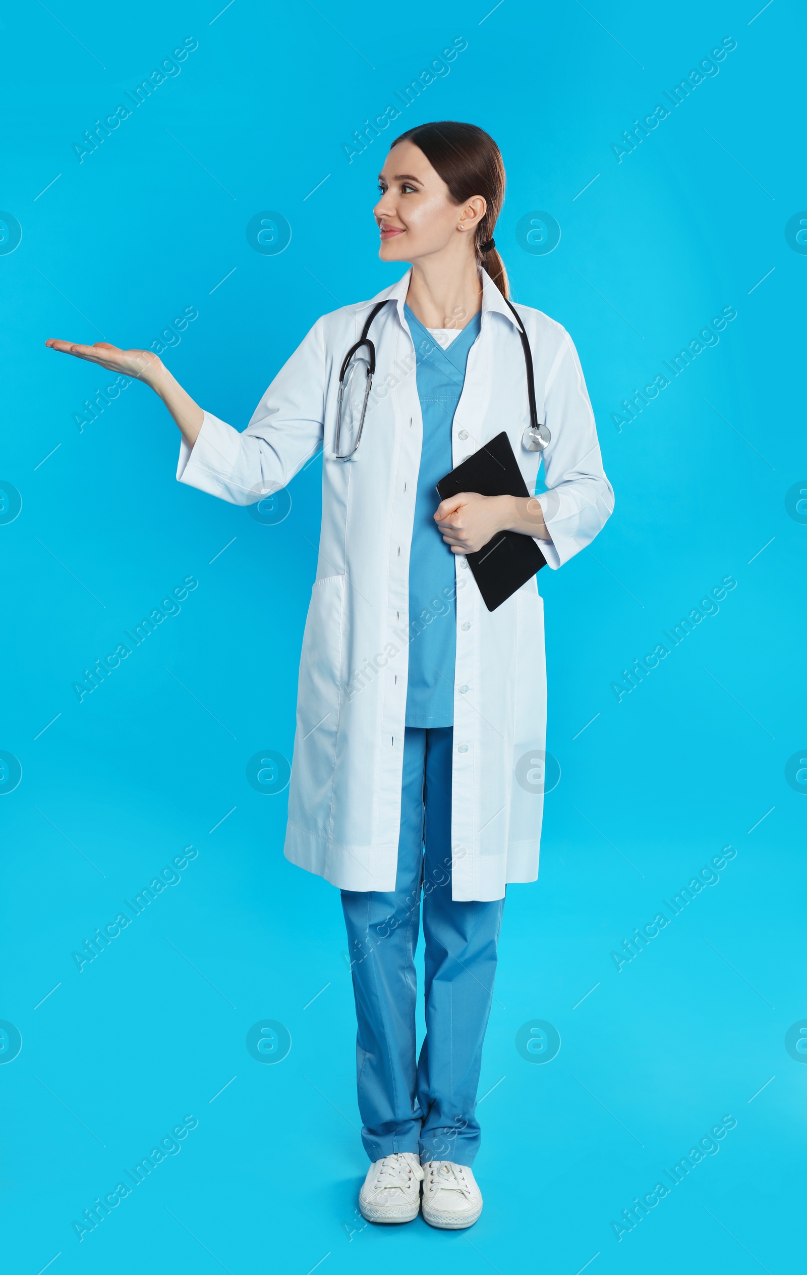 Photo of Doctor with stethoscope and clipboard on blue background