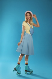 Young woman with retro roller skates on color background