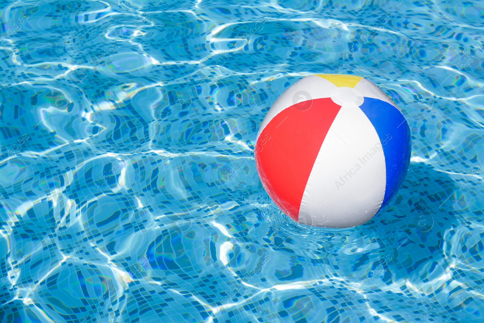 Photo of Inflatable beach ball floating in swimming pool, space for text