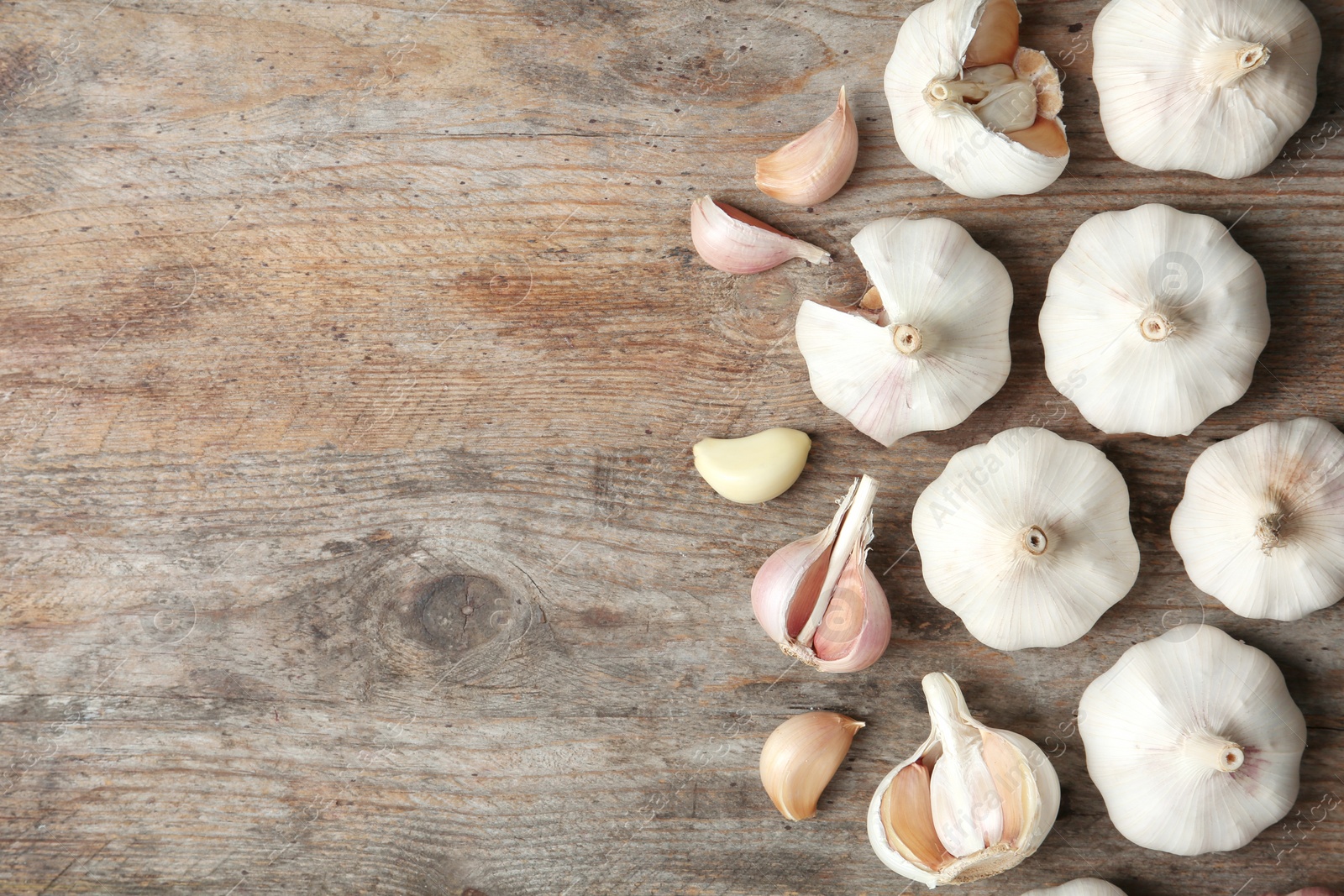 Photo of Flat lay composition with garlic and space for text on wooden background