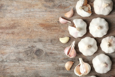 Photo of Flat lay composition with garlic and space for text on wooden background