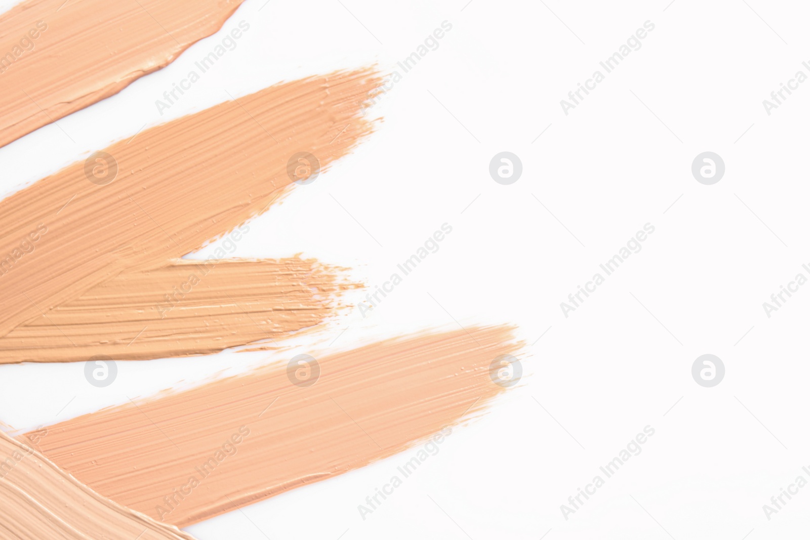 Photo of Samples of different foundation shades on white background, top view