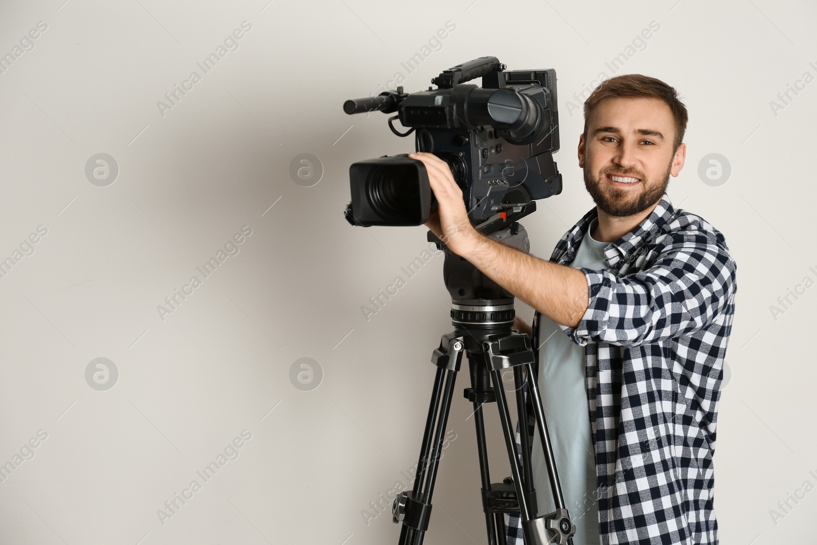 Photo of Operator with professional video camera on white background