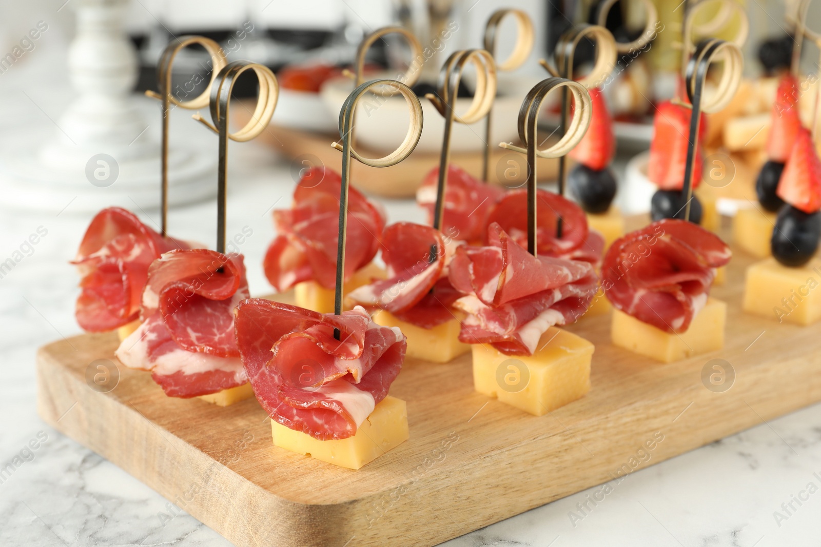 Photo of Different tasty canapes on white marble table, closeup