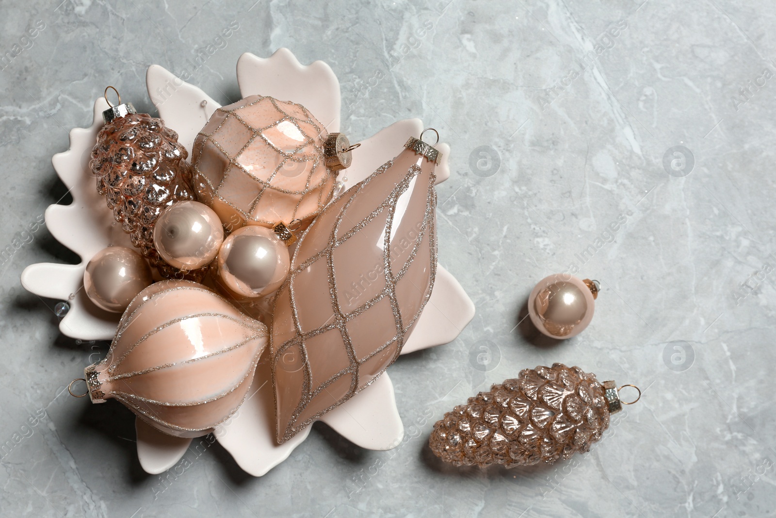 Photo of Collection of beautiful Christmas tree baubles on grey table, flat lay