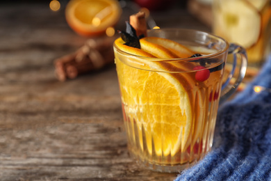 Aromatic mulled wine on wooden table, closeup. Space for text