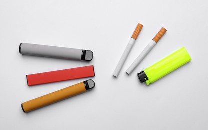 Photo of Lighter, electronic and regular cigarettes on white background, top view