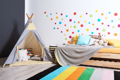 Modern child room interior with bed and play tent