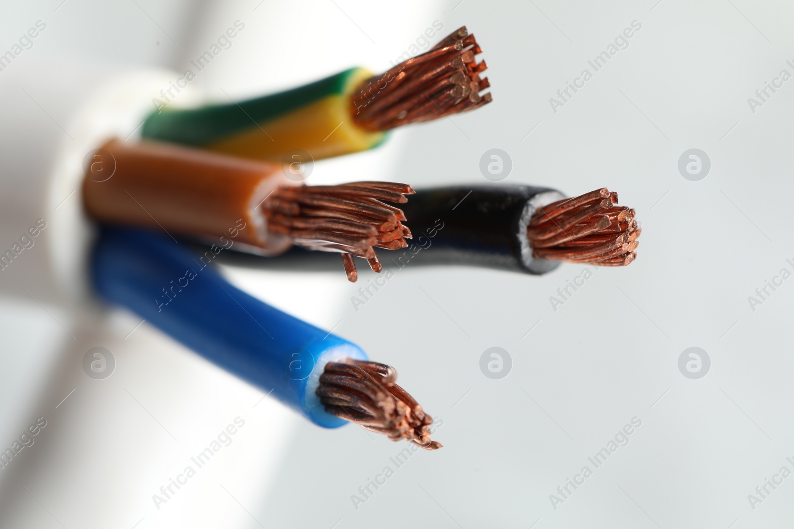 Photo of Colorful electrical wires on light background, closeup