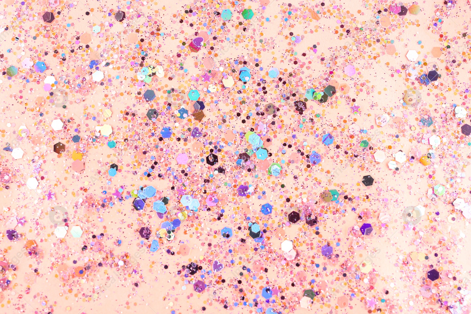 Photo of Shiny glitter on light pink background, top view