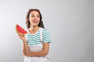 Photo of Beautiful young woman with watermelon on grey background. Space for text