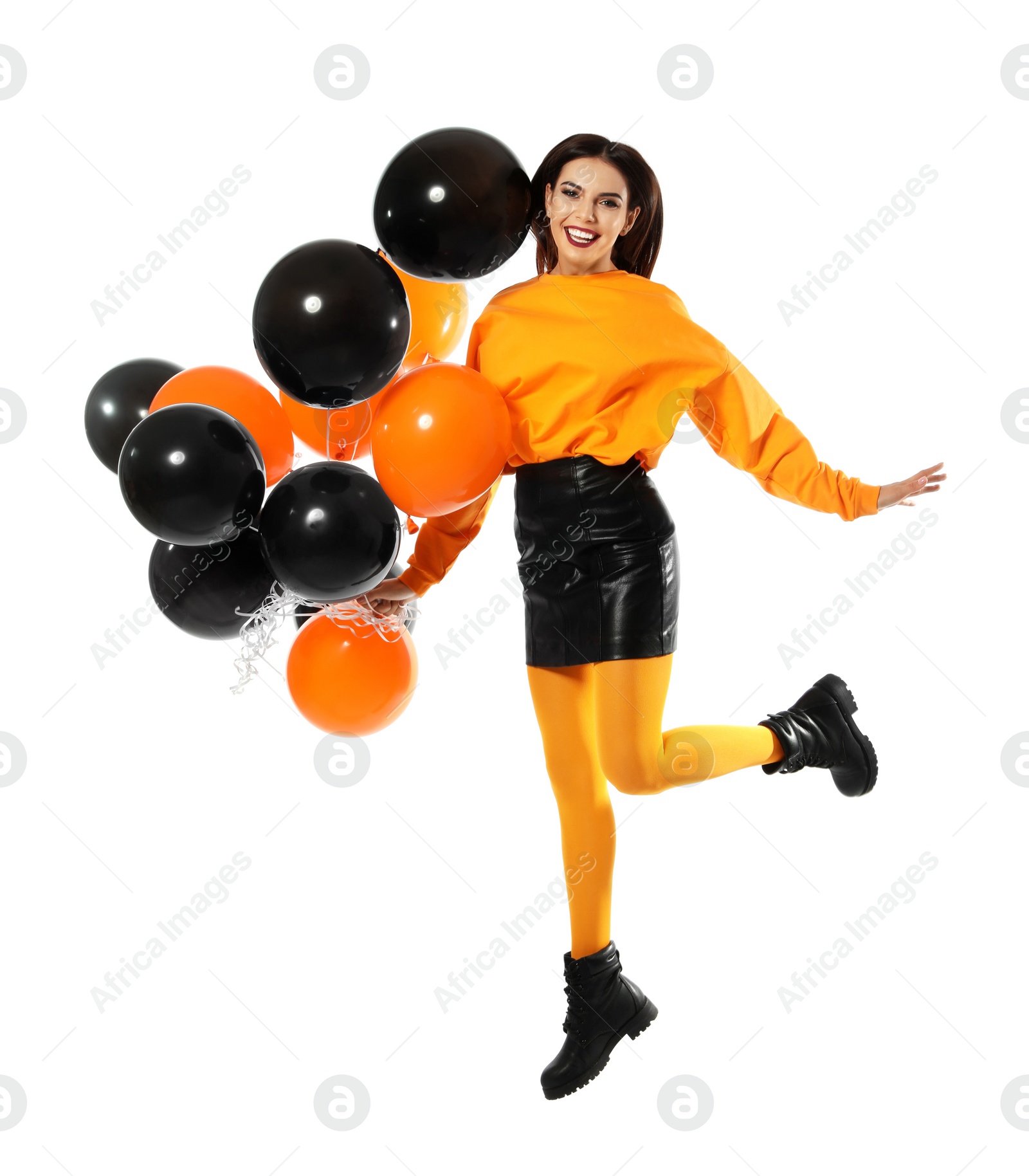 Photo of Beautiful woman with balloons jumping on white background. Halloween party