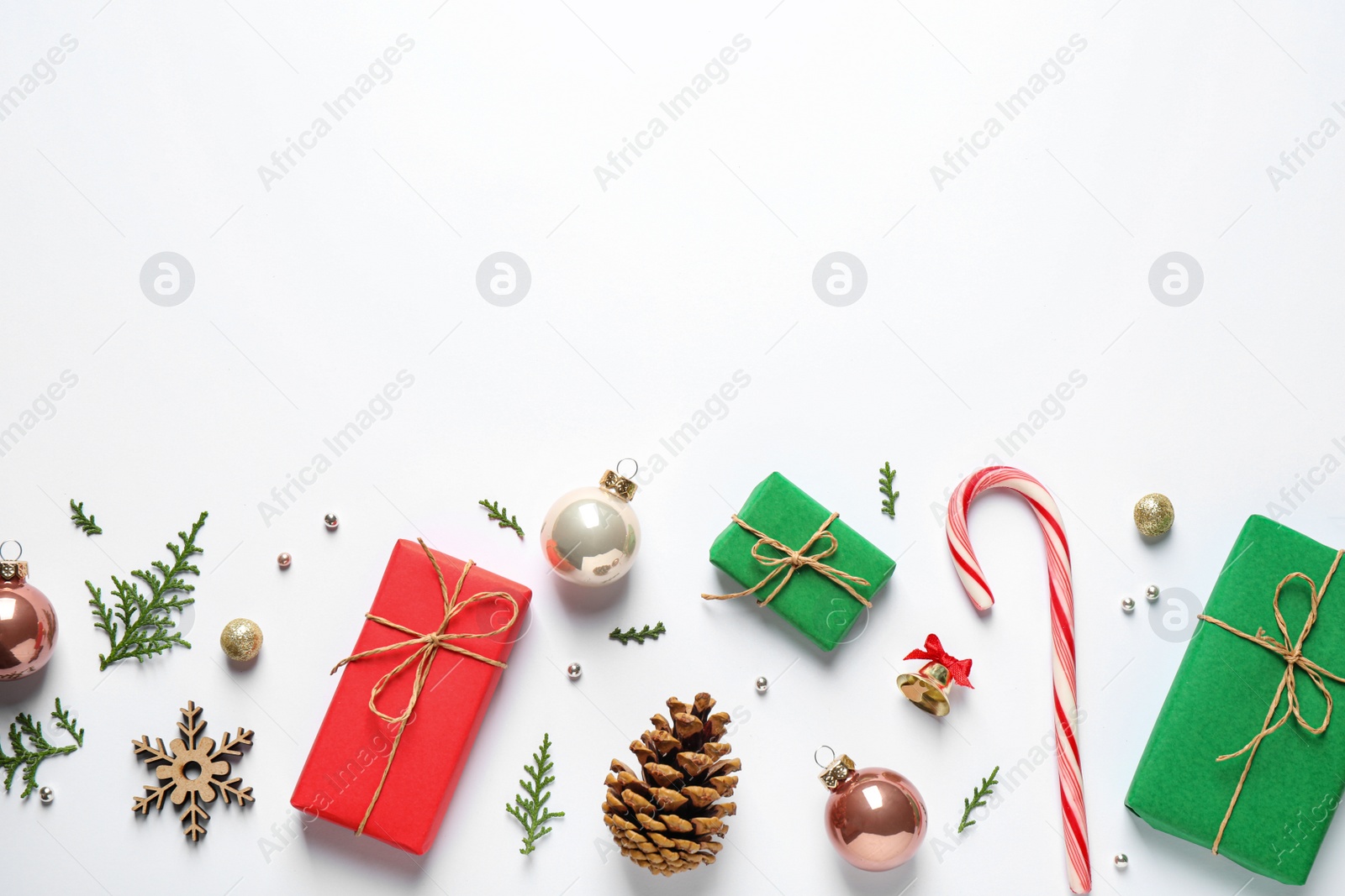 Photo of Flat lay composition with Christmas gifts and festive decor on white background. Space for text