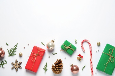 Flat lay composition with Christmas gifts and festive decor on white background. Space for text