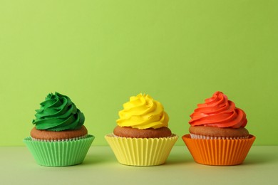 Different delicious cupcakes on color background, space for text