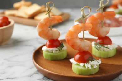 Photo of Tasty canapes with shrimps, vegetables and cream cheese on white marble table, closeup