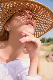 Beautiful woman with straw hat outdoors on sunny day