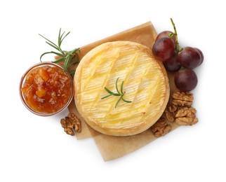 Tasty baked brie cheese with grapes, walnuts and jam isolated on white, top view