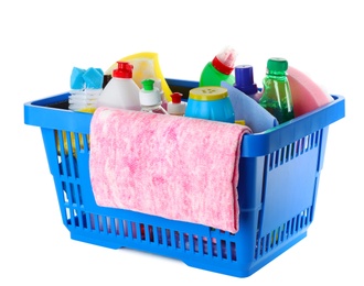 Photo of Shopping basket with different detergents and rag on white background