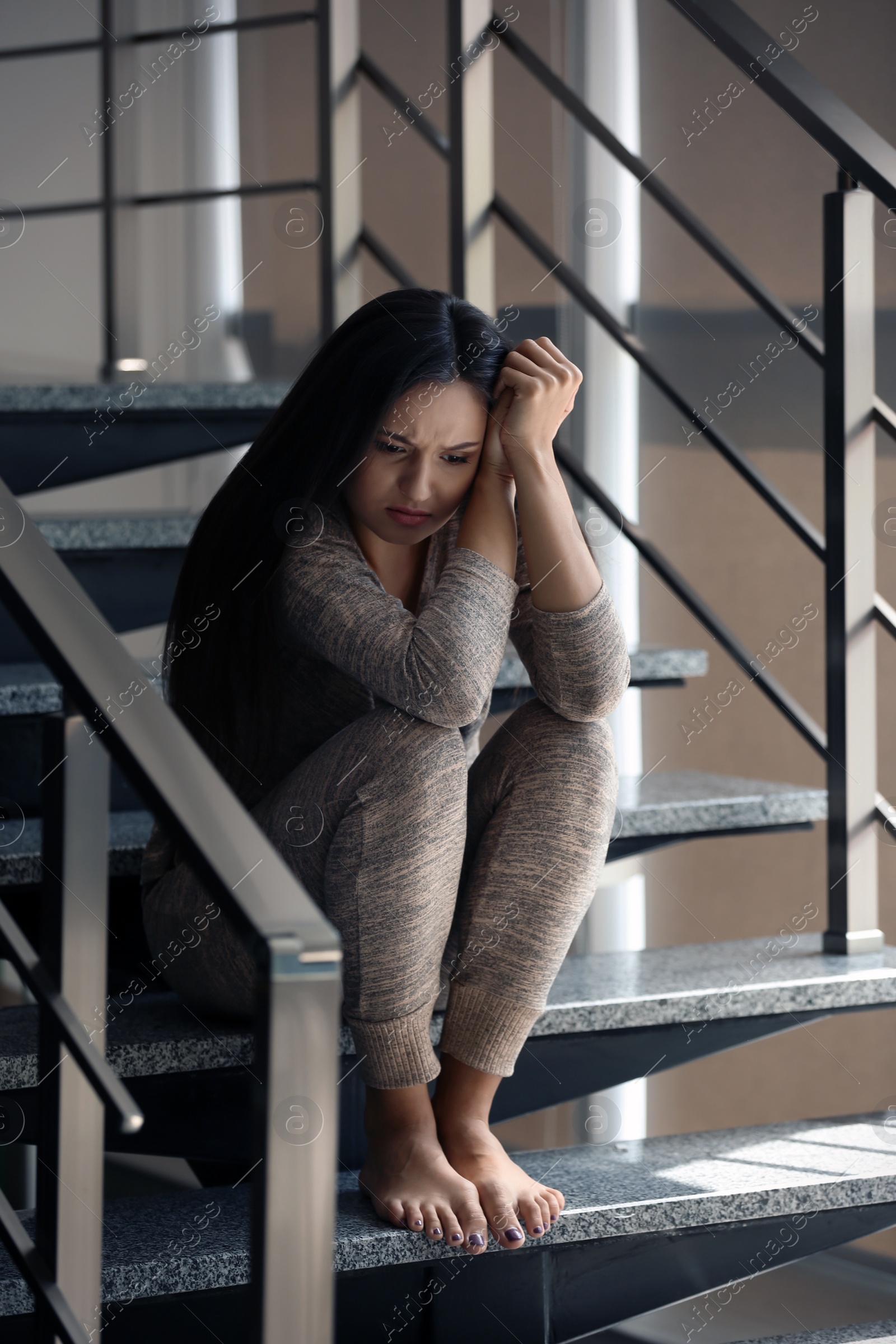 Photo of Depressed young woman sitting on stairs