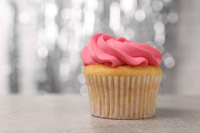 Photo of Delicious cupcake with bright cream on grey table, closeup. Space for text