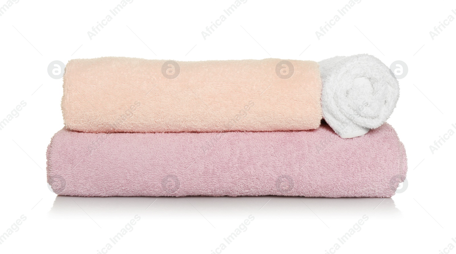 Photo of Folded and rolled soft terry towels on white background